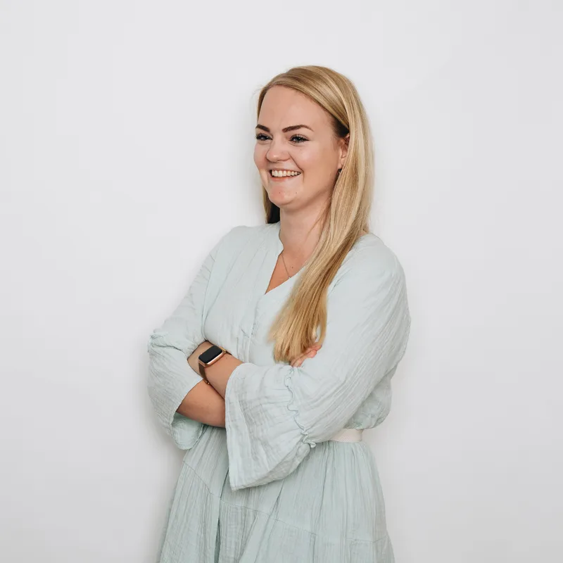 Dominique Bakker standing with arms folded against a light background.