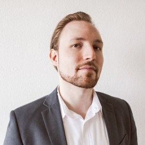 Marijn van de Bree in een donkere blazer voor een lichte achtergrond.